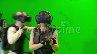 虚拟现实中的战斗。 在绿色背景下，VR头盔中的人在虚拟现实中玩游戏。