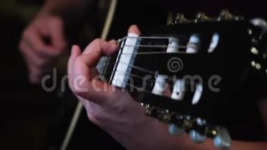 音乐和艺术的概念.. 概念。 男人`双手演奏黑色吉他的特写镜头