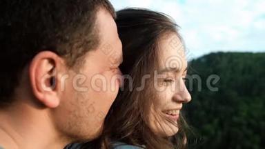 一个年轻的女人在她男朋友的怀里开心地笑。