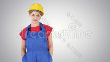 微笑的建筑工人妇女站立和改变姿势折叠手，双手在臀部，双手在口袋在梯度