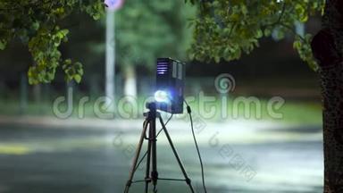 投影仪灯光光束用于在空路背景下夜间在街道上显示照片和视频材料。 艺术。 视频
