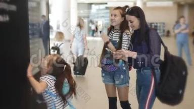 母亲和女儿在机场检查机票，然后才报名。