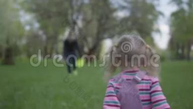 哥哥和妹妹跑在美丽的绿色公园里。 小女孩摔倒了，男孩帮她站起来。 快乐