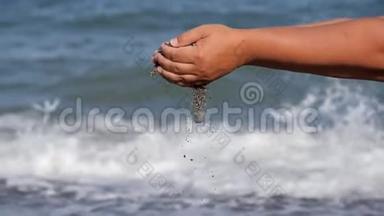 海上休息。 手中的一个小贝壳在汹涌的海浪的背景下掉落下来。 贝壳瀑布