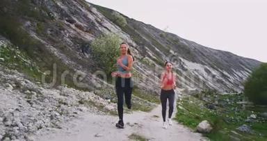 两位深黑肤色的女士在山中央用石块<strong>使劲</strong>地跑着，她们很高兴在那里一起享受锻炼