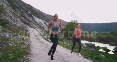 非常漂亮的女人穿着运动服，在令人惊叹的山景中在一起，快乐地享受着