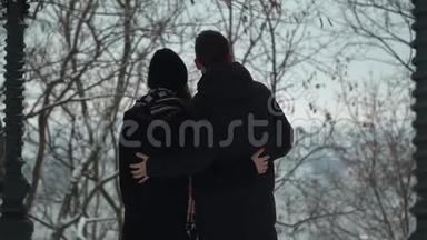年轻夫妇在冬天的公园里拥抱着<strong>雪</strong>。 冬闲的幸福恩爱夫妻.. 年轻日期