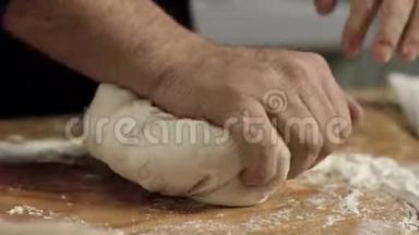 专业面包师揉面团特写。库存录像。面包师傅的大手在面团上揉面粉
