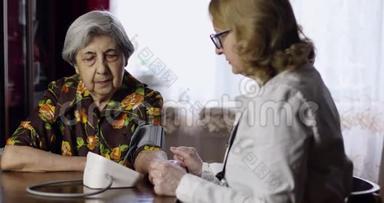 一位老年医生在室内测量一位老年妇女的血压。