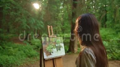 年轻女子在公园里用油画画风景