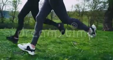 细<strong>节</strong>特写在大自然中，两个<strong>跑步</strong>的女士一边拍着腿的视频，一边穿过草地，旁边的草地