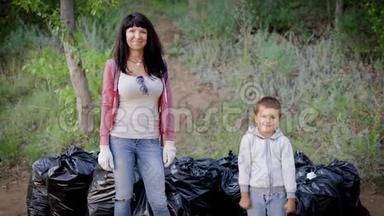 母亲向儿子展示她的榜样，清理森林里的垃圾是很重要的。 环境教育