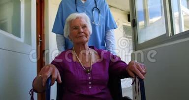 高加索女医生在疗养院推轮椅的老年病人的正面景色