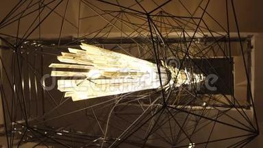 特写美丽非凡的灯被金属几何线条包围.. 概念。 博物馆展览