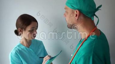 护士和一位住院医生讨论一位病人`治疗方案。 诊所医务人员工作
