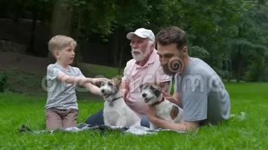 多代家庭<strong>遛狗</strong>。 爸爸爷爷和儿子和杰克鲁塞尔猎犬玩得开心，笑吻