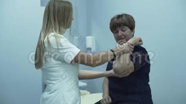 职业白种人医生检查坐在办公室的一名老年妇女的手臂。 成熟的女士检查她的健康