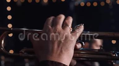 小号演奏者。 小号手演奏铜管乐器。 把小号演奏者的手指靠近