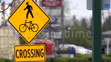 人的运动和自行车交叉标志在人行道上与模糊的交通流
