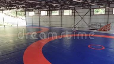 一个大型摔跤健身房，没有人用<strong>垫</strong>子和蓝色覆盖橙色标记。 一块叫做t的武术<strong>地毯</strong>