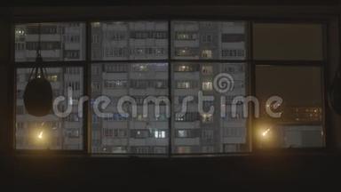 从旧房子的窗户看，晚上有窗户。 库存录像。 从体育大厅可以看到全景窗口