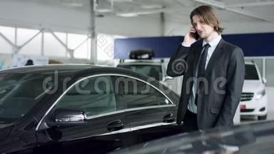专业的汽车销售人员告诉有兴趣的买家在<strong>车展</strong>上豪华的汽车，而男人正在与经销商交谈