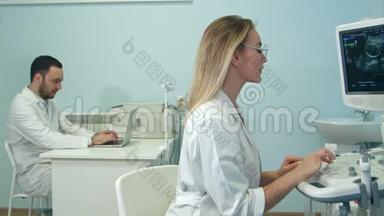 女医生用手提电脑向她的男同事口述超声波检测结果