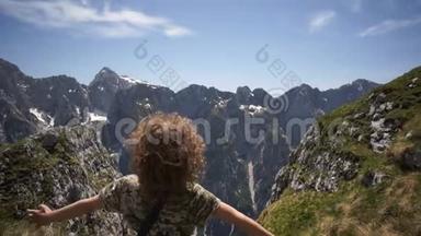 暑假里快乐的孩子站在悬崖边，欣赏山的自然背景