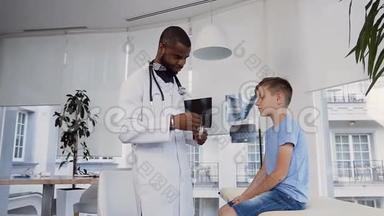 可爱的小男孩向看着他喉咙的年轻医生张开嘴。