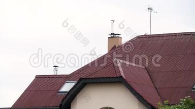 <strong>一座</strong>城市房屋的美丽屋顶，在多云的天空背景下有红色的屋顶瓷砖。 库存录像。 新住宅门面
