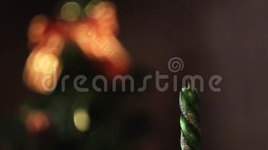 点燃和熄灭的圣诞蜡烛在模糊的圣诞树剪影上特写，灯光和