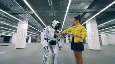 一个带平板电脑的女人打<strong>开机</strong>器人，控制着它。