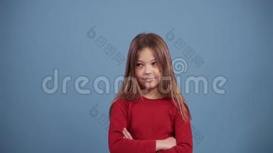可爱的长发女孩穿红色毛衣不意的没有手势，做否定手指的手势。 拒绝，拒绝
