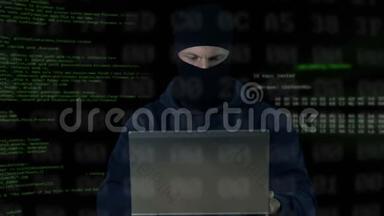 戴口罩的罪犯检查笔记本电脑和手机上的监控摄像头，数据库