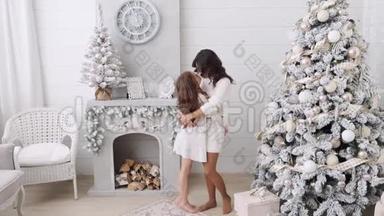 妈妈和<strong>女儿</strong>的背景是一个美丽的圣诞节内饰。 壁炉旁边的<strong>一家人</strong>妈妈和<strong>女儿</strong>