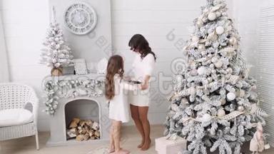 妈妈和<strong>女儿</strong>的背景是一个美丽的圣诞节内饰。 壁炉旁边的<strong>一家人</strong>妈妈和<strong>女儿</strong>