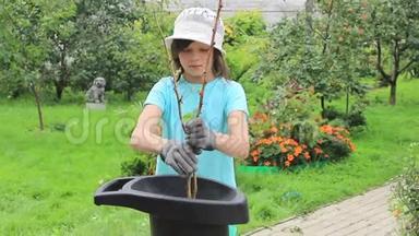 女孩用花园碎纸机在花园里工作