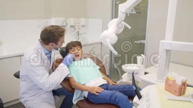 一个快乐的小男孩在成功的牙科检查后向他的牙医献殷勤