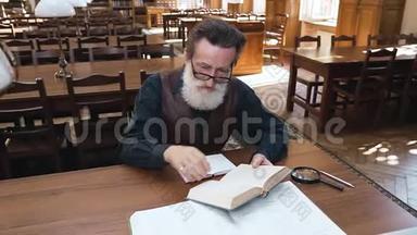 吸引人的是专注于看书的留胡子戴眼镜的<strong>老</strong>人坐在图书馆的桌子旁拿着书