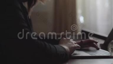 女商人坐在笔记本电脑前的桌子上，键盘上的打字机贴了上去。 女人`双手合拢