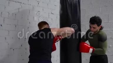 拳击手训练用拳击袋进行跆拳道训练。 拳击手在手套里打拳击，在战斗中打拳击