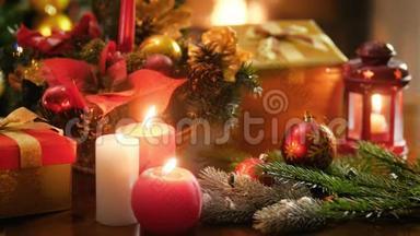 特写4k视频，在木桌上燃烧蜡烛，对抗圣诞装饰品，并在壁炉中燃烧火焰。 完美完美完美