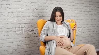幸福的孕妇裸着大肚子抚摸着鲜橙汁中弹