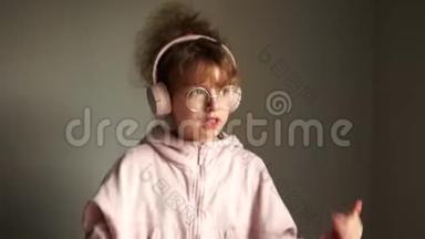 可爱的十几岁女孩戴着眼镜，卷发，用无线耳机听音乐。 蓝牙技术