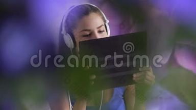 微笑的女人在耳机里欣赏音乐的肖像。 耳机时尚模特