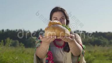 可爱丰满的女人在白面包上提出猪油的肖像，微笑着看着相机。 招待费