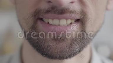 一个满脸胡须的成年男子的下颚特写，试图用强迫的微笑微笑。 消极情绪，问题