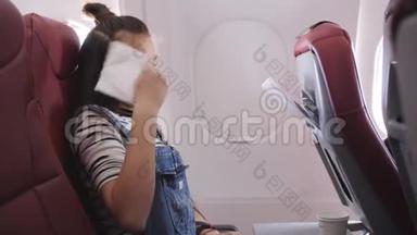 飞机上的少女呕吐在纸袋里。 乘坐飞行飞机的旅行者会感到恶心。 在飞行中的恶心乘客