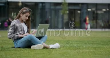 女孩用笔记本电脑在互联网上查找信息。 一个漂亮的<strong>女大学生</strong>坐在阴凉处