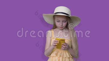 戴<strong>帽</strong>子的夏天女孩在紫色背景下看手机。 少年少女<strong>夏季</strong>服装和<strong>帽</strong>子使用